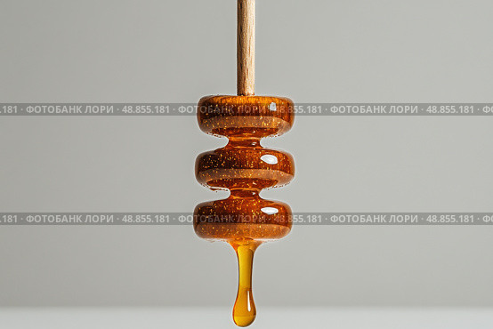 Honey Dripper With Golden Honey Droplet Against a Simple Background in a Kitchen Setting. Стоковое AI-изображение, AI-художник Юлия Гапеенко / Фотобанк Лори