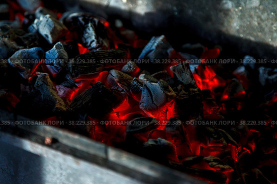 Hot coals. Coal combustion. Close-up of red-hot coals blazing on grill. Close up. View from top. Dark background for creative process. Barbecue process. Home cooking. Стоковое фото, фотограф Aleksandr Golubev / Фотобанк Лори