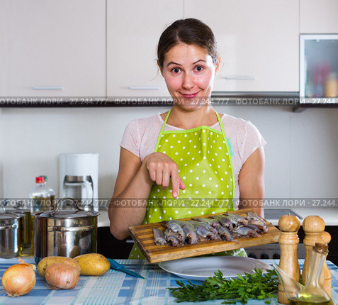 housewife trying new recipe of sprattus in kitchen. Стоковое фото, фотограф Яков Филимонов / Фотобанк Лори