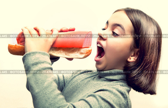 Hungry girl with open mouth and with giant bread and sausage sandwich on white background. Стоковое фото, фотограф Элина Гаревская / Фотобанк Лори