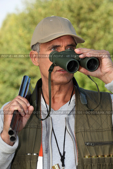 Hunter looking through binoculars. Стоковое фото, агентство Ingram Publishing / Фотобанк Лори