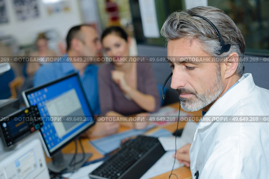 Husband whispering to wife during meeting. Стоковое фото, агентство Ingram Publishing / Фотобанк Лори