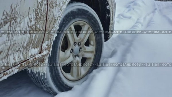 Icy car. Wheel skids in the snow. Frozen Auto. Ice covered Vehicle during Snowstorm. Hazardous Winter Road Driving. Cold Season. Corrosion, Rust. Close-up of tires. Trail of tread marks in thick snow. Стоковое AI-видео, аниматор Марина Демидюк / Фотобанк Лори