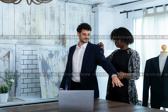 In a modern clothes fashion room, a clothing designer or tailor allows buyers to try on molded outfits before sewing them. Стоковое фото, агентство Ingram Publishing / Фотобанк Лори