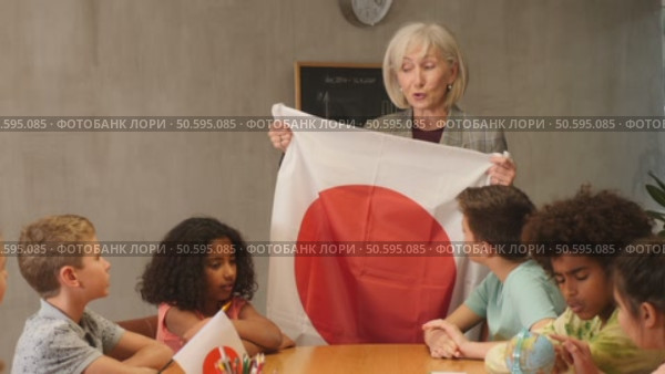 in geography lesson, students carefully listen to woman teacher who talks about Japan. Стоковое видео, видеограф Яков Филимонов / Фотобанк Лори