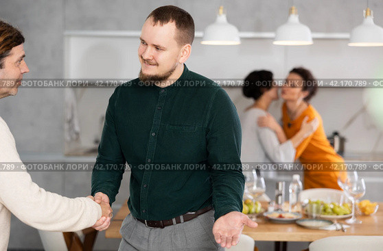In home, male friends shake hands, say goodbye after socializing and gatherings. Стоковое фото, фотограф Яков Филимонов / Фотобанк Лори