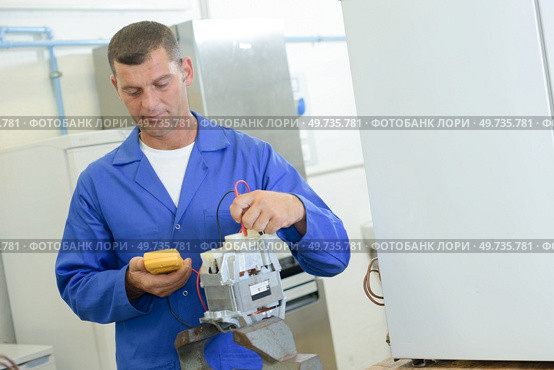 industrial technician reading a voltmeter. Стоковое фото, агентство Ingram Publishing / Фотобанк Лори