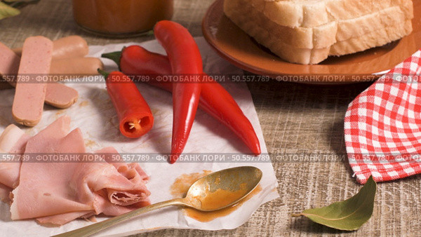 Ingredients preparations of traditional Portuguese snack food. Francesinha sandwich of bread, cheese, pork, ham, sausages. On table. Стоковое фото, агентство Ingram Publishing / Фотобанк Лори
