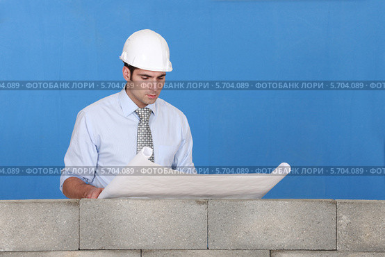 инженер на стройке смотрит чертеж. Стоковое фото, фотограф Phovoir Images / Фотобанк Лори