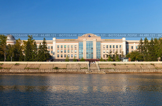IRKUTSK, RUSSIA - August 18, 2024: View from Angara River to Gagarin Boulevard embankment and  IRGIREDMET building - Rare Metals and Diamonds Research Institute. Beautiful summer cityscape. Редакционное фото, фотограф Виктория Катьянова / Фотобанк Лори