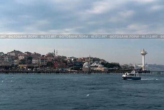 Istanbul, Turkey, 02.25.2023: View of the Uskyudar district in the Asian part of Istanbul and the Shemsi Ahmed Pasha Mosque from the Bosporus water area on a sunny day. Редакционное фото, фотограф Ula Ulachka / Фотобанк Лори