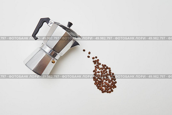 Italian coffee maker and fresh coffee beans in the form of a dripping drop on a white background with copy space. Flat lay. Coffee beans in the form of a drop dripping from a metal coffee maker on a white background with space for text. Concept of morning coffee. Flat lay. Стоковое фото, агентство Ingram Publishing / Фотобанк Лори