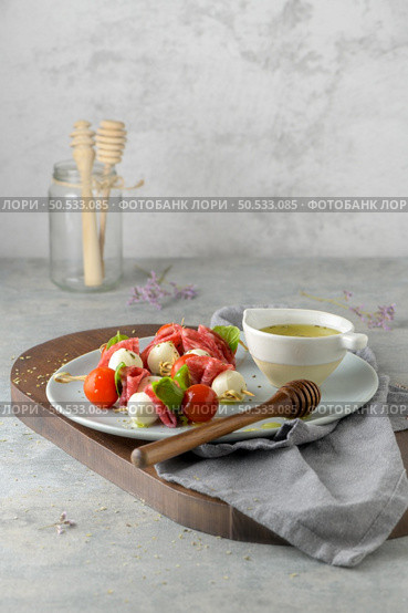 Italian style appetizer, antipasto skewer or caprese on a stick with basil, salami, mozarella and tomatoes. Стоковое фото, агентство Ingram Publishing / Фотобанк Лори