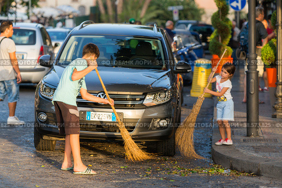 Италия. Сиракузы. Дети подметают улицу в городе. Italy. Syracuse. Children sweep the street in the city. (2017 год). Редакционное фото, фотограф Алексей Смышляев / Фотобанк Лори