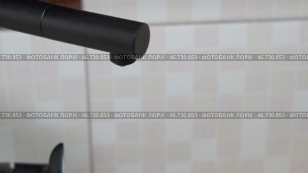 Из черного крана капает водопроводная вода. Крупный план. Оригинальный звук. Стоковое видео, видеограф Sergei Gorin / Фотобанк Лори