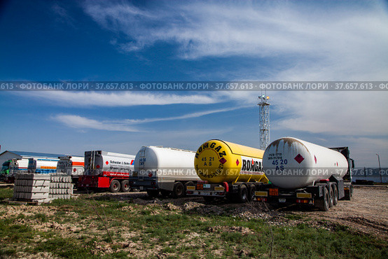 Jambyl region, Kazakhstan - April 25 2012: Oil refinery and gas processing plant. Oil tanker car on parking of filling station. Blue sky with clouds. Редакционное фото, фотограф Alexey Rezvykh / Фотобанк Лори