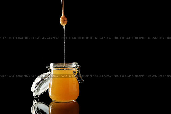 Jar and dipper with tasty honey on dark background. Стоковое фото, фотограф Pixel_shot / Фотобанк Лори