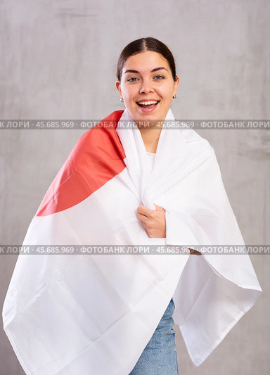 Joyous young woman holding Japan flag against unicoloured background. Стоковое фото, фотограф Яков Филимонов / Фотобанк Лори