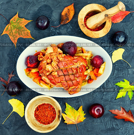 Juicy pork shoulder with skin and bacon cooked with plums. Top view. Pork shoulder roasted with vegetables and plums. Стоковое фото, агентство Ingram Publishing / Фотобанк Лори