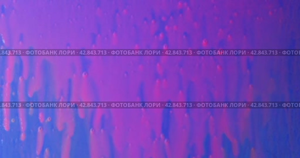 Капли розовой флуоресцентной краски падают на голубой фон и стекают вниз ручьями. Красочный фон. Drops of pink fluorescent paint fall on a blue background and flow down streams. Стоковое видео, видеограф Александр Собко / Фотобанк Лори