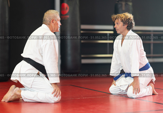 Karate student and sensei in white gi bowing in dojo. Стоковое фото, фотограф Яков Филимонов / Фотобанк Лори
