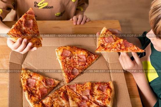 kids eating pizzas together. Стоковое фото, агентство Ingram Publishing / Фотобанк Лори
