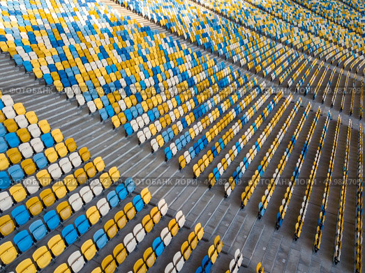KIEV, UKRAINE - July 19, 2018. Panoramic view from drone on empty even rows tribunes of sports complex NSC Olimpiysky before soccer game in the summer time.. KYIV, UKRAINE - July 19, 2018. Aerial view empty tribunes of NSC Olimpiysky before the game in blue and yellow colors. Редакционное фото, агентство Ingram Publishing / Фотобанк Лори
