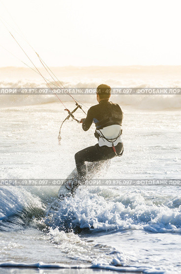 Kitesurfer in action on a beautiful background of spray during the sunset. Стоковое фото, агентство Ingram Publishing / Фотобанк Лори