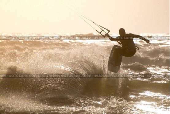 Kitesurfer jumping on a beautiful background of spray during the sunset. Стоковое фото, агентство Ingram Publishing / Фотобанк Лори