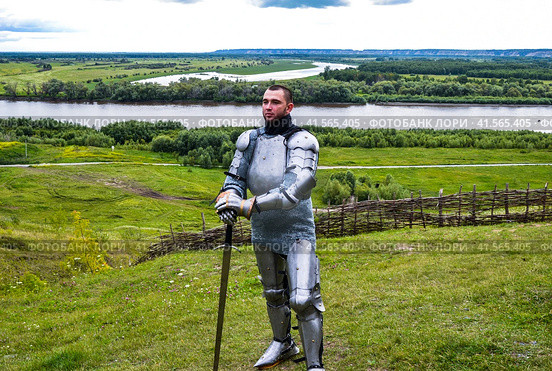 knight in armor stands against the background of native open spaces, forests and a river. Knightly armor and weapon. Стоковое фото, фотограф Леонид Еремейчук / Фотобанк Лори
