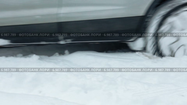 Колеса автомобиля проезжающего по сугробам на заснеженной дороге (2015 год). Редакционное видео, видеограф Кекяляйнен Андрей / Фотобанк Лори