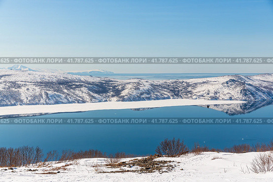 Красивый пейзаж с морским заливом, побережьем и горами, покрытыми снегом. Весна на северо-востоке России. Бухта Нагаева, Охотское море. Магаданская область, Дальний Восток России. Стоковое фото, фотограф Андрей Степанов / Фотобанк Лори