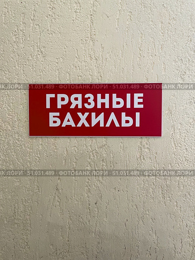 Красная табличка на стене с белой надписью "Грязные бахилы". Вывеска в медицинском учреждении, поликлинике или больнице. Стоковое фото, фотограф Евгений Ковальский / Фотобанк Лори