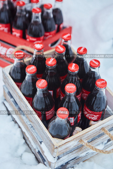 Krasnodar, Russia - December 10, 2021: Glass bottles of Coca-Cola on the street during the snow. Редакционное фото, фотограф Наталия Кирсанова / Фотобанк Лори