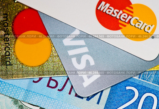 Кредитные карточки с логотипами MasterCard и Visa и рублевые купюры. Редакционное фото, фотограф E. O. / Фотобанк Лори