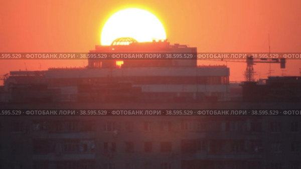 Крупным планом восходящее солнце позади городских зданий. Стоковое видео, видеограф Цыбин Вадим / Фотобанк Лори