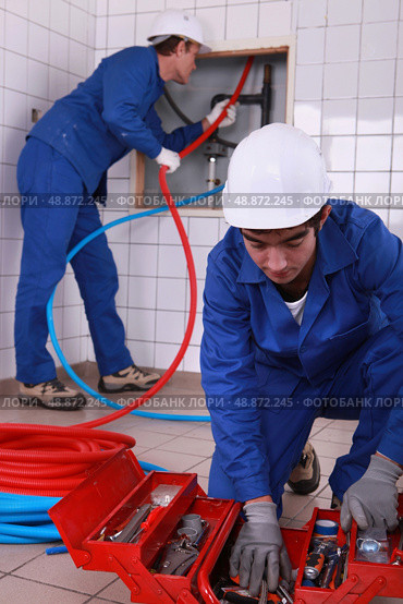 laborers installing tube. Стоковое фото, агентство Ingram Publishing / Фотобанк Лори