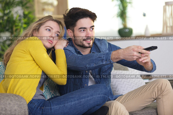 lady bored while boyfriend enjoys the television programme. Стоковое фото, агентство Ingram Publishing / Фотобанк Лори