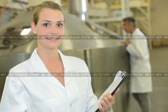 Lady with clipboard in front of large vat. Стоковое фото, агентство Ingram Publishing / Фотобанк Лори