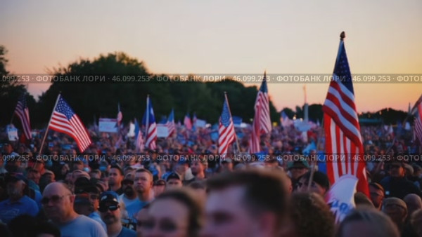 Large crowd of people are holding American flags and protesting. Стоковое AI-видео, аниматор Sergey Grishin / Фотобанк Лори