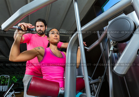 Lat Lateral dorsal pulldown machine upper back woman with personal trainer man. Стоковое фото, агентство Ingram Publishing / Фотобанк Лори
