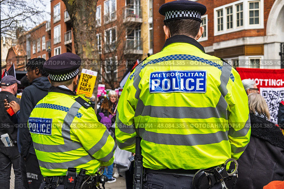 Law enforcement presence at a street protest ensuring safety. London, UK, 16 March 2024. Редакционное фото, фотограф Zydrius Tartenis / Фотобанк Лори