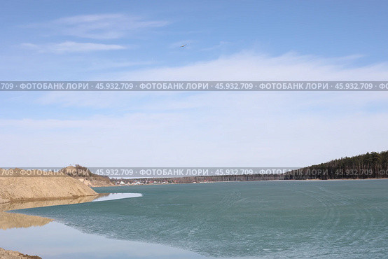 Легкомоторный самолёт над искусственным водоёмом обводненный карьер Рудас затянутый тающим бирюзовым льдом. Деревня Манушкино, Колтушское городское поселение, Всеволожский район, Ленинградская область. (2019 год). Стоковое фото, фотограф Сергей Комаров / Фотобанк Лори