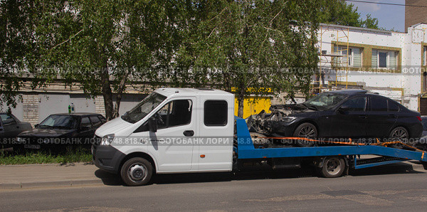 Легковой автомобиль после аварии доставлен в автосервис на эвакуаторе. Саратов. Редакционное фото, фотограф Евгений Будюкин / Фотобанк Лори