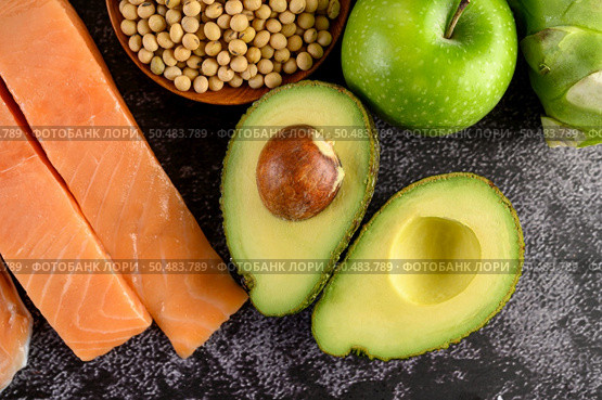 Legumes, fruit, and salmon placed on a black cement floor. Стоковое фото, агентство Ingram Publishing / Фотобанк Лори