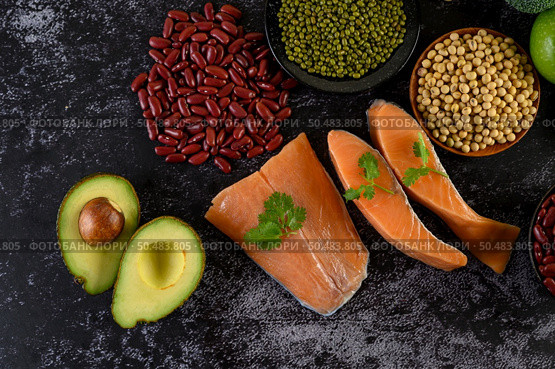 Legumes, fruit, and salmon placed on a black cement floor. Стоковое фото, агентство Ingram Publishing / Фотобанк Лори