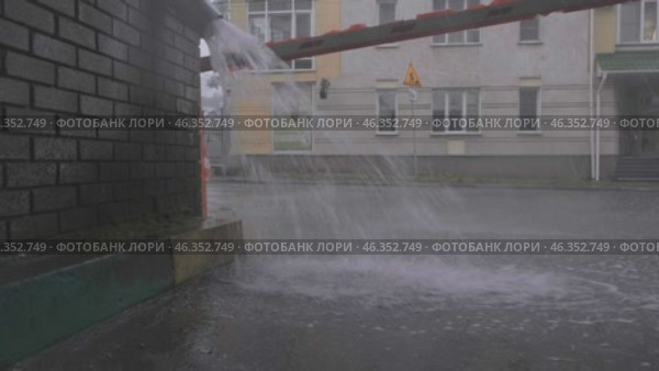 Летний ливень в городе. Поток воды из водосточной трубы (2024 год). Редакционное видео, видеограф Илья Старков / Фотобанк Лори