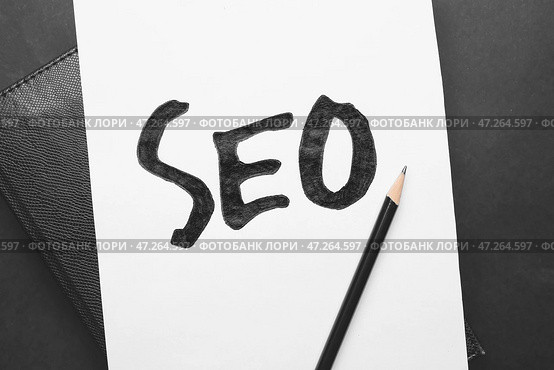 Лист бумаги с аббревиатурой SEO, блокнот и карандаш на темном фоне. Стоковое фото, фотограф Pixel_shot / Фотобанк Лори