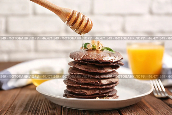 Лить мед на вкусные шоколадные блины на тарелке. Стоковое фото, фотограф Pixel_shot / Фотобанк Лори