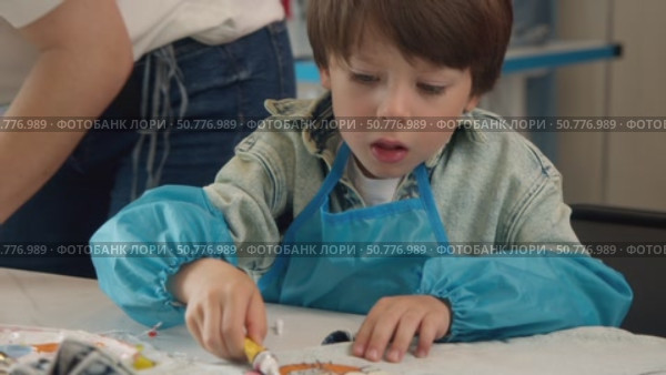 little boy is engaged in process of making handmade garments during an art class. Стоковое видео, видеограф Strunov David / Фотобанк Лори